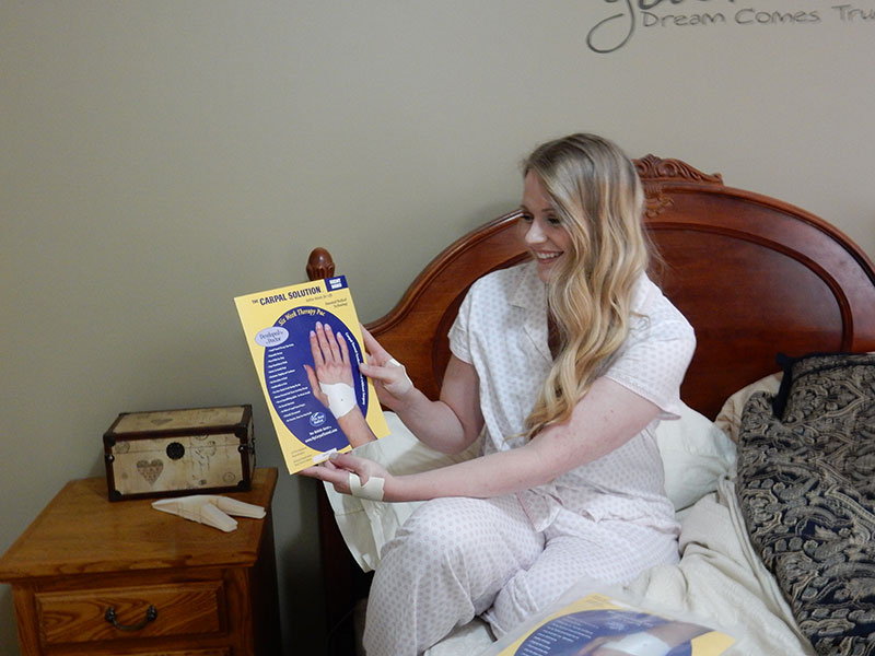 woman-using-the-carpal-soluion-in-bed woman demonstrating how to use the carpal solution to get a full nights sleep