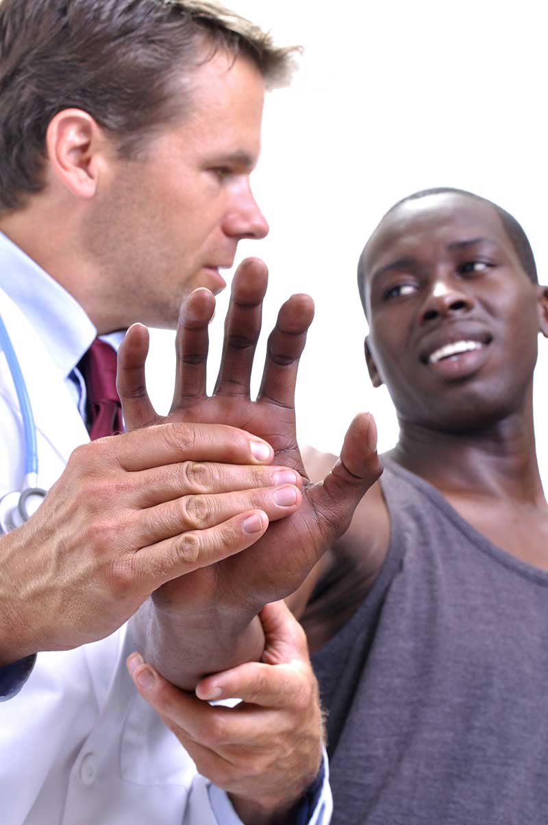 doctor working on man with hand pain 