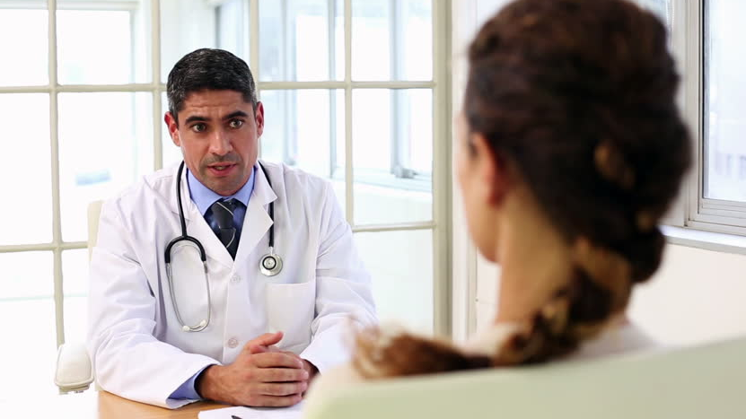 Carpal Tunnel Relief 4 Doctor speaking with a female patient during a medical consultation.