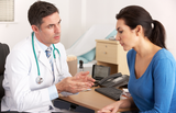 Doctor consulting with a female patient in a medical office.