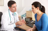 Doctor consulting with a female patient in a medical office.