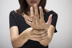 Carpal Tunnel Treatment Options: Splints, Therapy, Injections, and Surgery 3 Person holding a sore wrist with the other hand. carpal tunnel treatment options