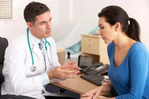 Carpal Tunnel Treatment Options: Splints, Therapy, Injections, and Surgery 4 Doctor speaking with a seated patient in an exam room.