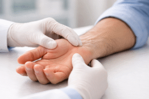 Doctor examining patient’s wrist and palm during hand evaluation.